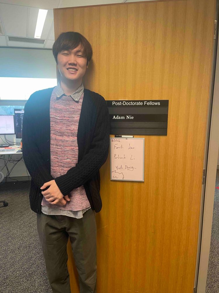 A photo of Yidi in front of his office