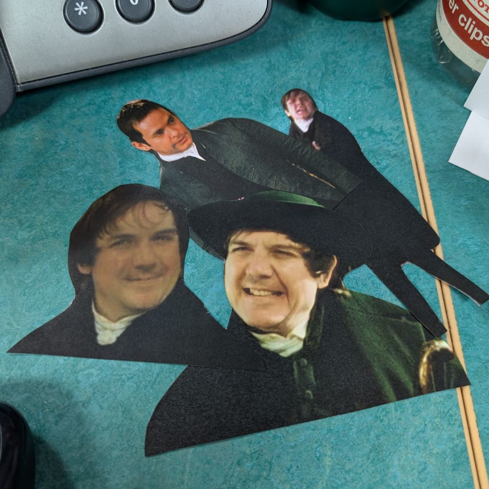 Four cut-out images of Mr Collins from Pride and Prejudice on a green desk.

3 are David Bamber (1995)
1 is Tom Hollander (2005)