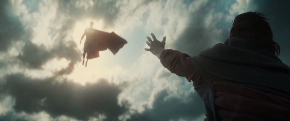 Superman floating to save a woman from the rooftop as a result of a flood 