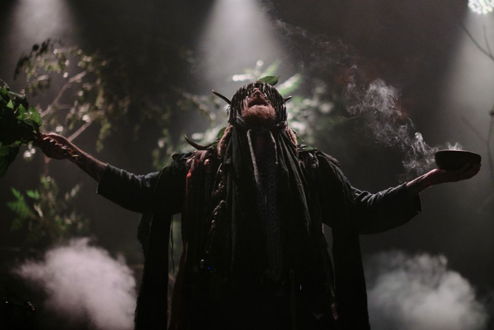 Heilung singer in a costume on stage