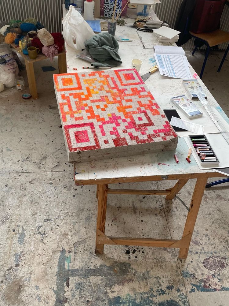 Beton bricks with a red/orange qr code painted on it.