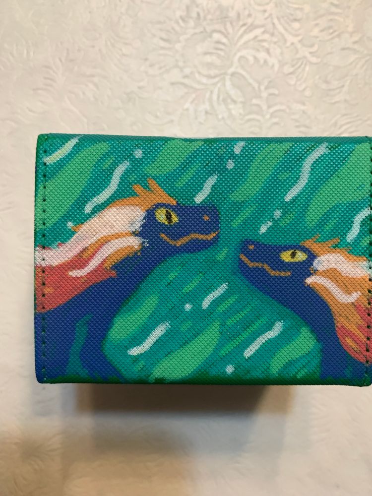 close up illustration of two little blue raptors with orange feathers 