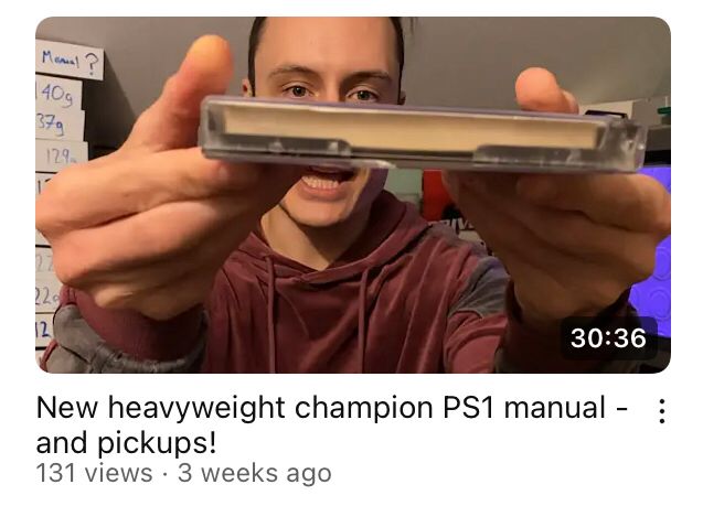 YouTube thumbnail for video called “new heavyweight champion ps1 manual - and pickups!” Goblin Retro is holding a really thick PS1 instruction manual 