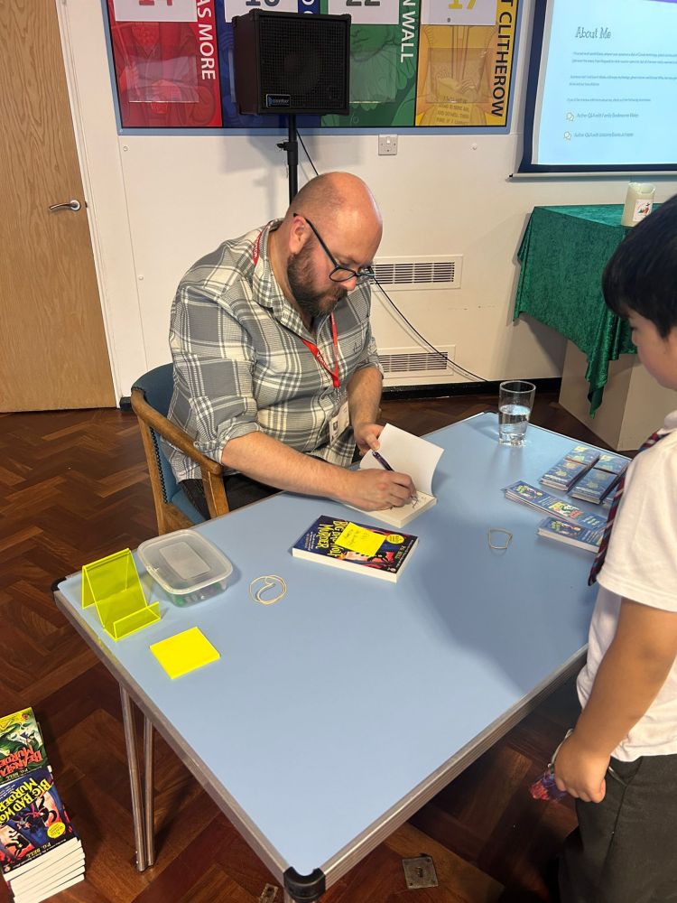 P G. Bell signing a copy of The Big Bad Wolf Murder for a school pupil 