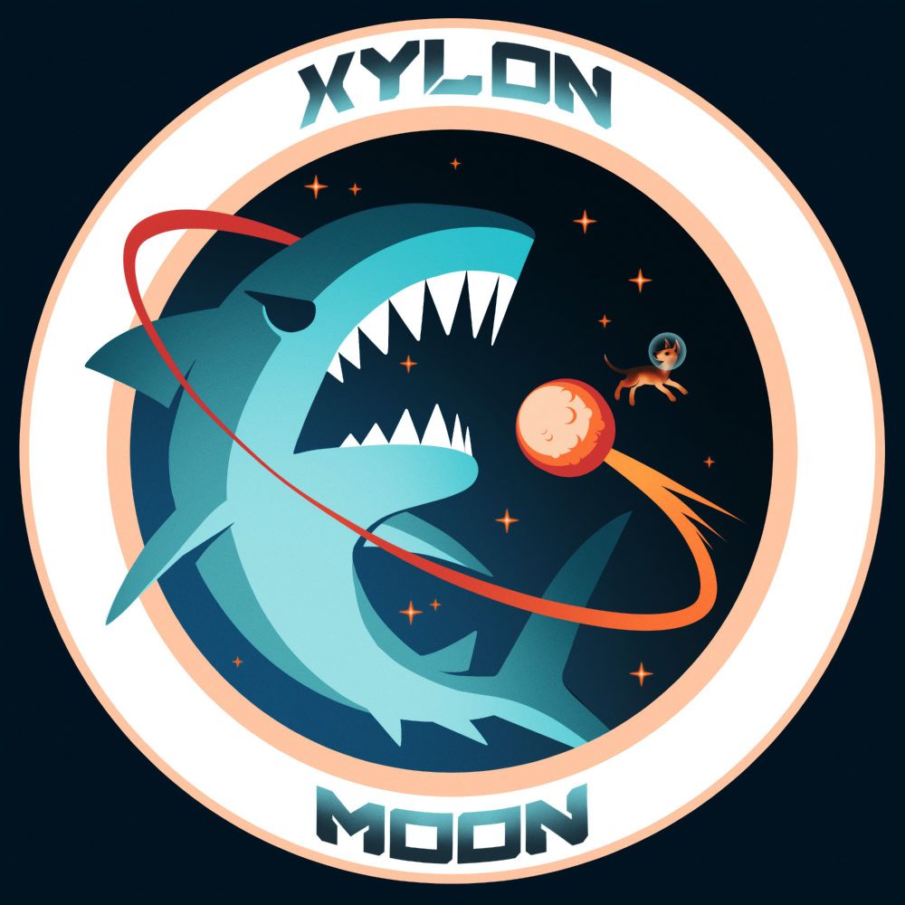 Pegatina de Xylon, inspirada en los parches de brazo de la NASA. Un tiburón azul es rodeado por la estela de un cometa del que está saltando una perrita marrón y negra con escafandra. El fondo degradado está lleno de pequeñas estrellas y todo se enmarca por una circunferencia dentro de la que se puede leer escrito "XYLON MOON". 