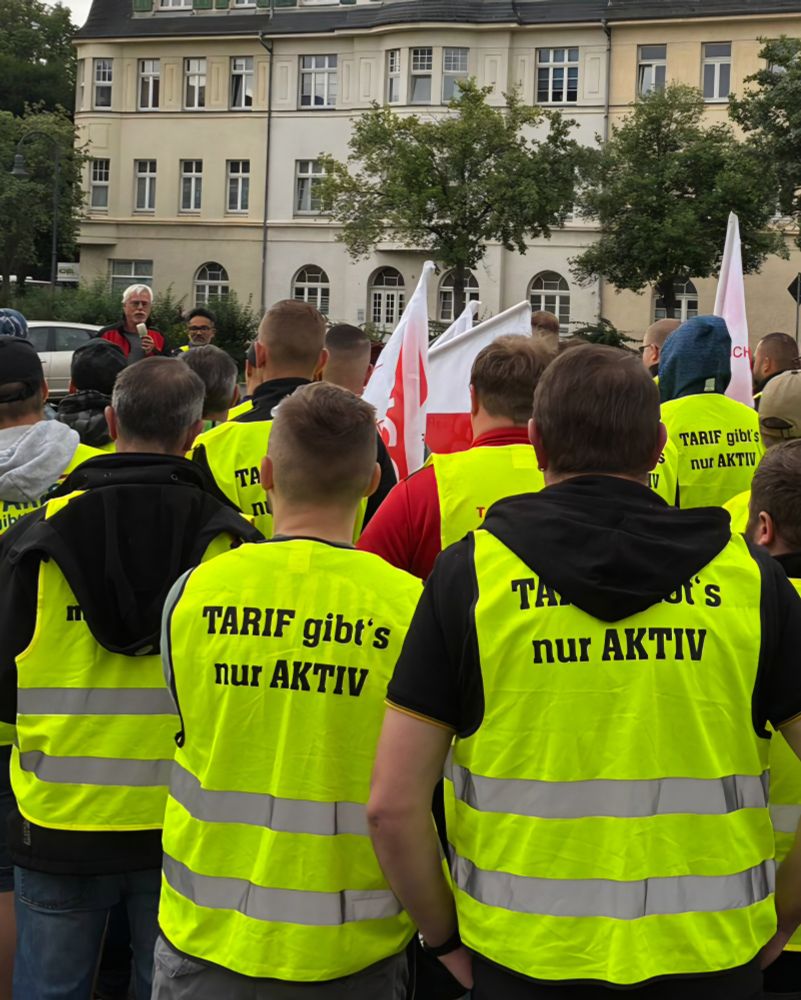 Auf dem Foto sind Menschen mit gelben Streikwesten und Fahnen zu sehen. Auf den Westen steht: Tarif gibt's nur aktiv.