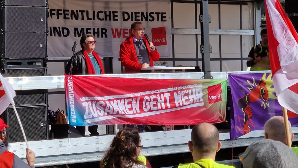 Redner und Rednerin auf der Bühne.
