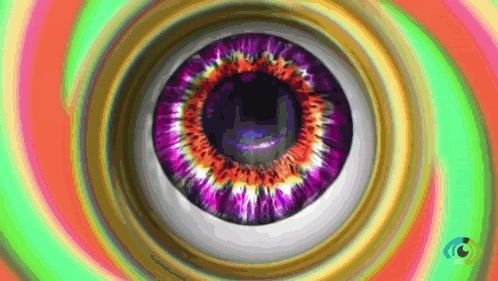 a close up of a purple eye in a hypnotic spiral .