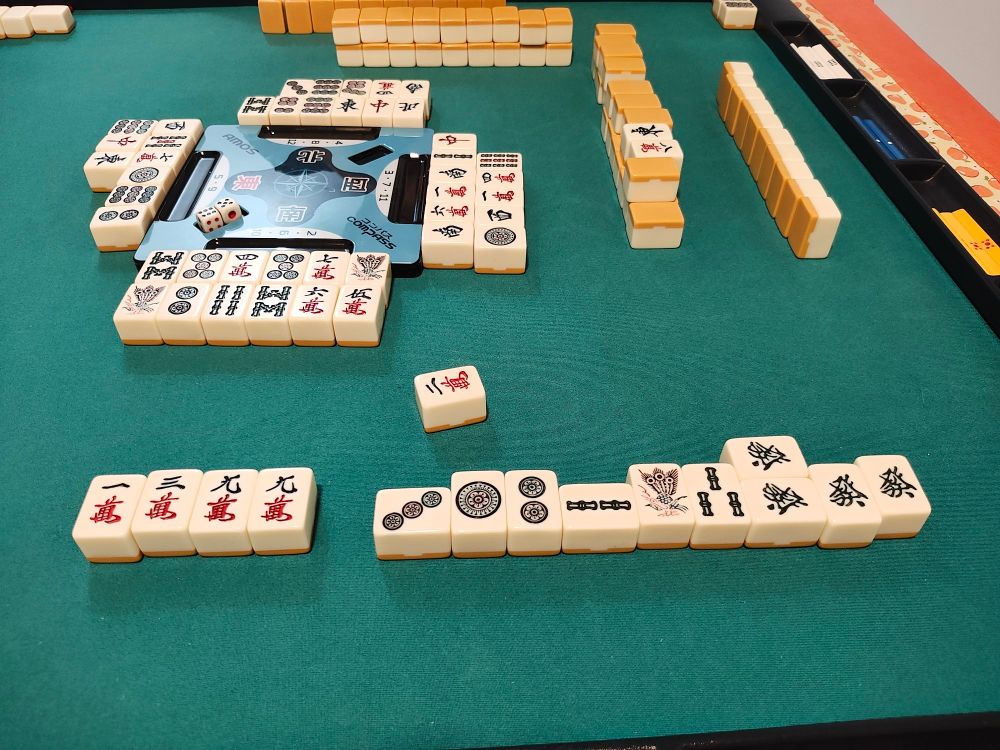 Foto de peças de mahjong depois de uma mão ganha. A mãos é um chanta, yakuhai, sanshoku doujun, com duas doras.