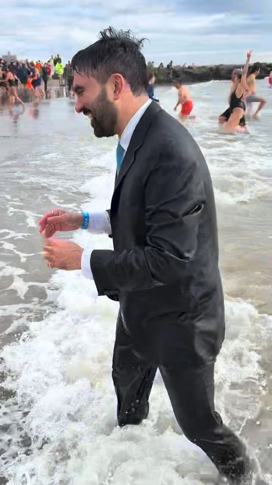 A dripping-wet Zohran Mamdani in a full suit