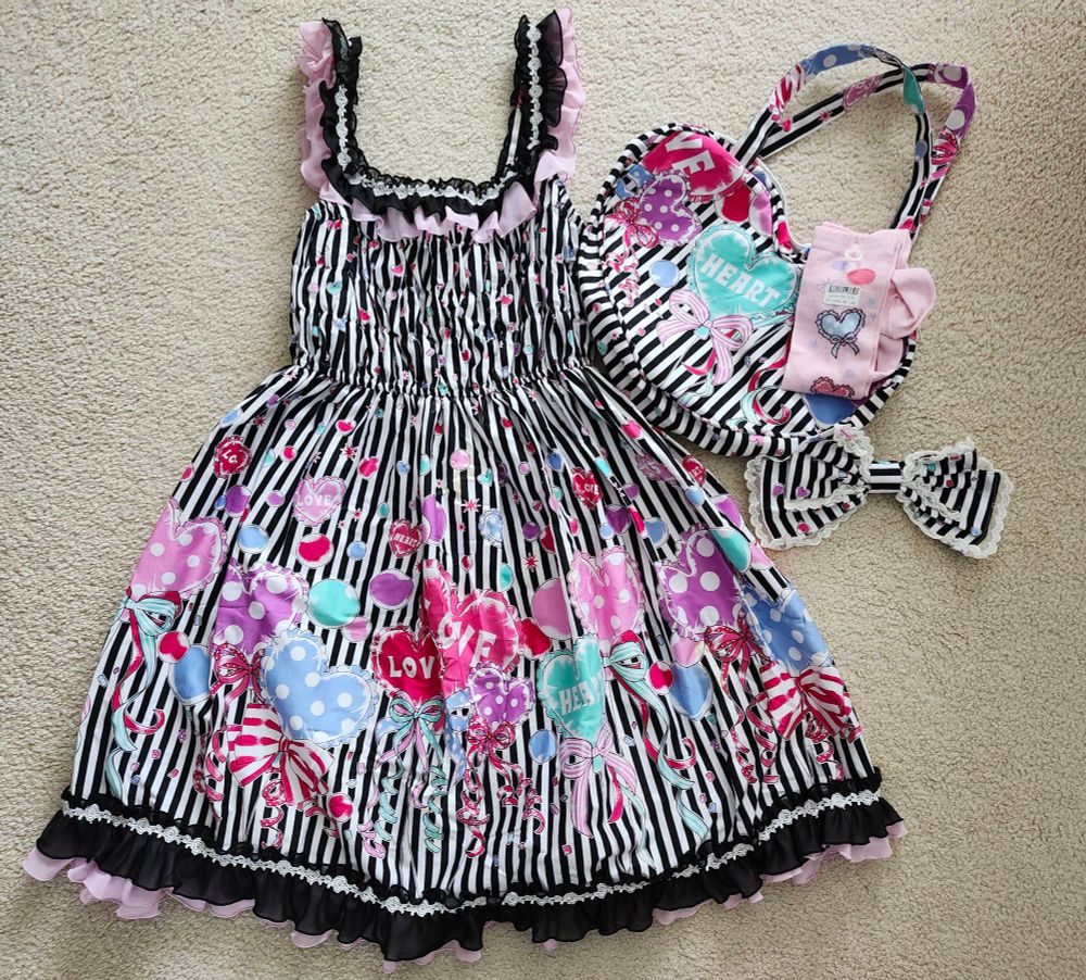 A flat-lay of bodyline's heart and balloon shirring jsk in black, with matching black tote bag, and pink socks.