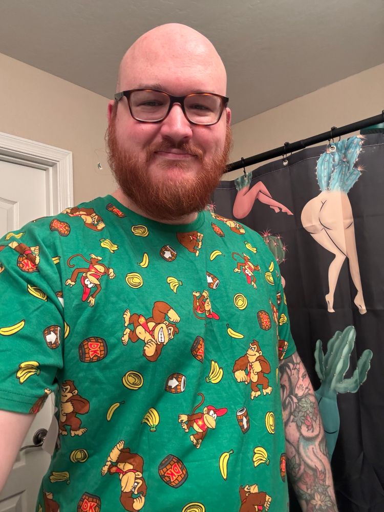 Clevers wearing a green pattern shirt with Donkey Kong, Diddy Kong, and bananas on it 