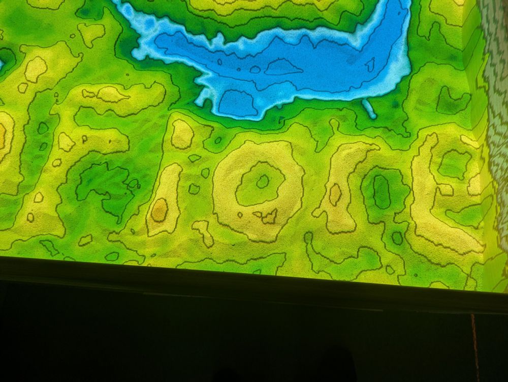 Topographic lines projected onto sand. 