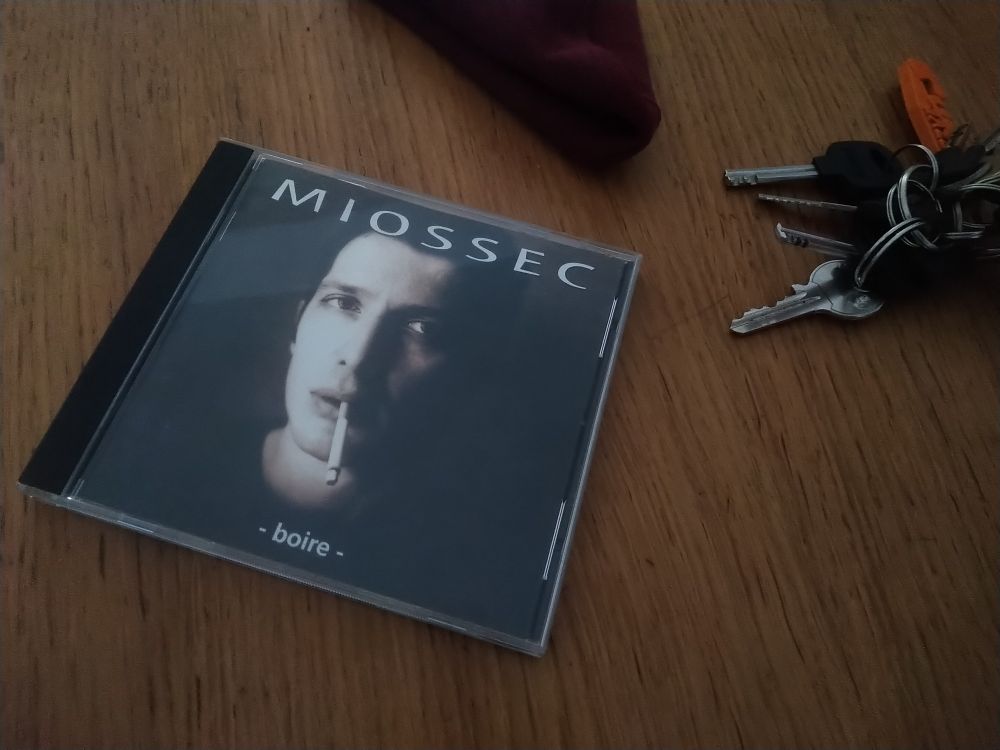 Album Miossec- Boire posé sur une table à côté d'un trousseau de clés.
