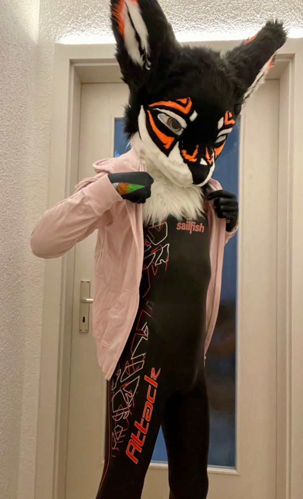 A rexouium fursuiter wearing a sailfish wetsuit and a jacket
