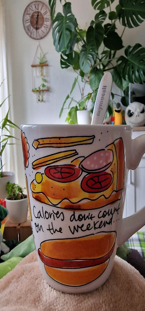 Eine große, bunte Tasse mit der Aufschrift "Calories don't count on the weekend" (Kalorien zählen am Wochenende nicht)