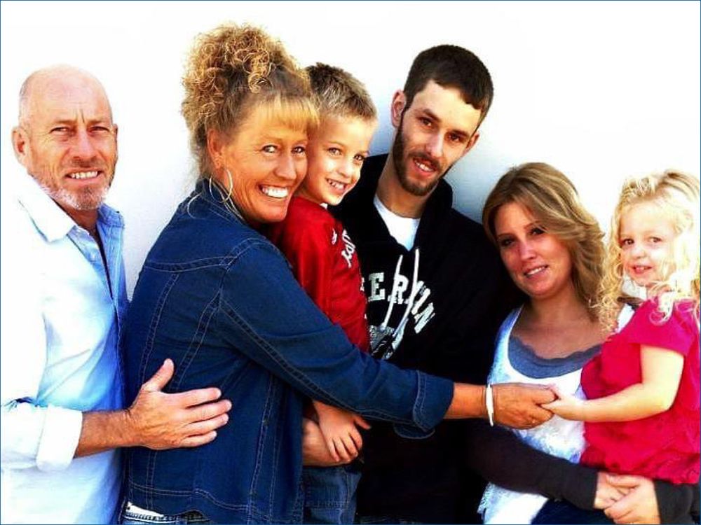 Photo of Debbie surrounded by loved ones in front of a white background.