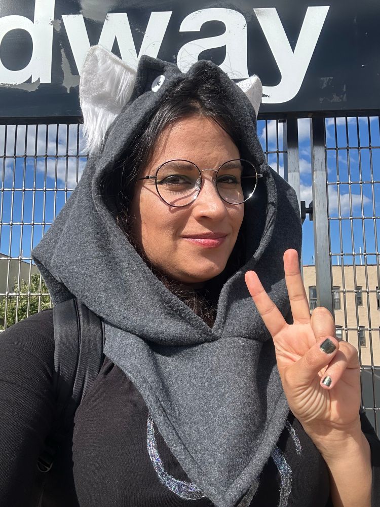 me flashin a peace sign as dog tier jade harley. i got white puppy ears, a grey hood, round glasses, and shirt with a swirly space aspect symbol on it.