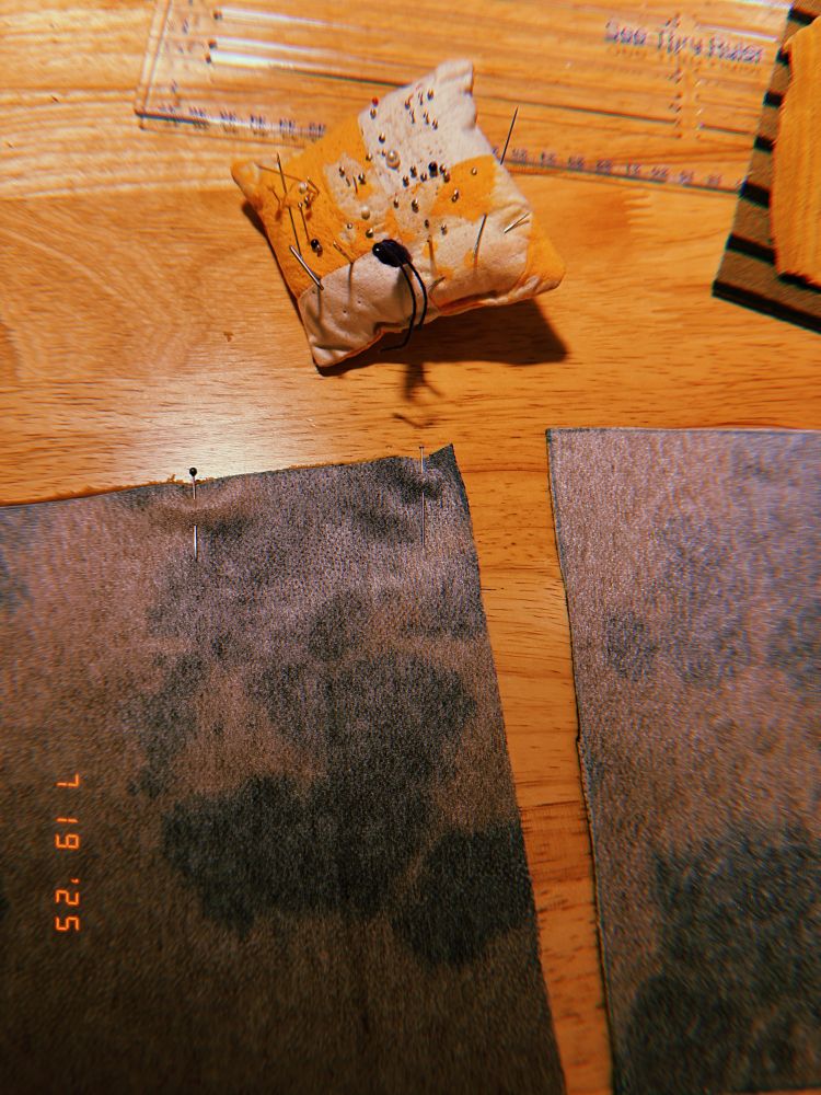 i am pinning the fabric squares together. you can see my pincushion and the wrong sides of two black & brown tie-dyed cotton squares.