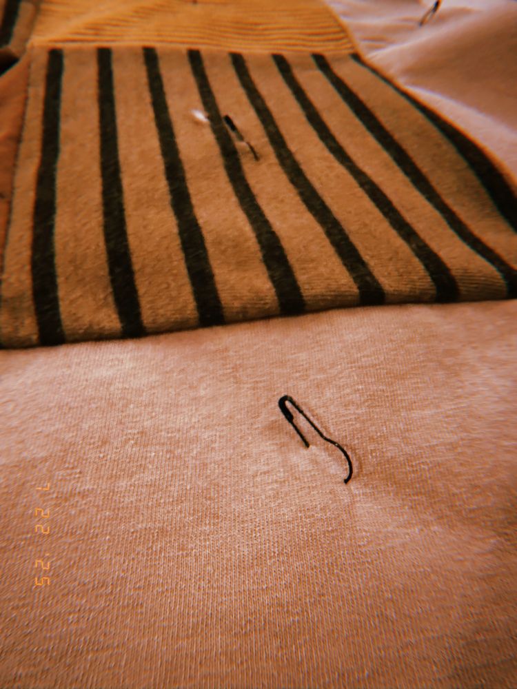 close up on one of the safety pins in the quilt. it’s like. one of those ones that has a big circle at the bottom instead of a normal safety pin loop