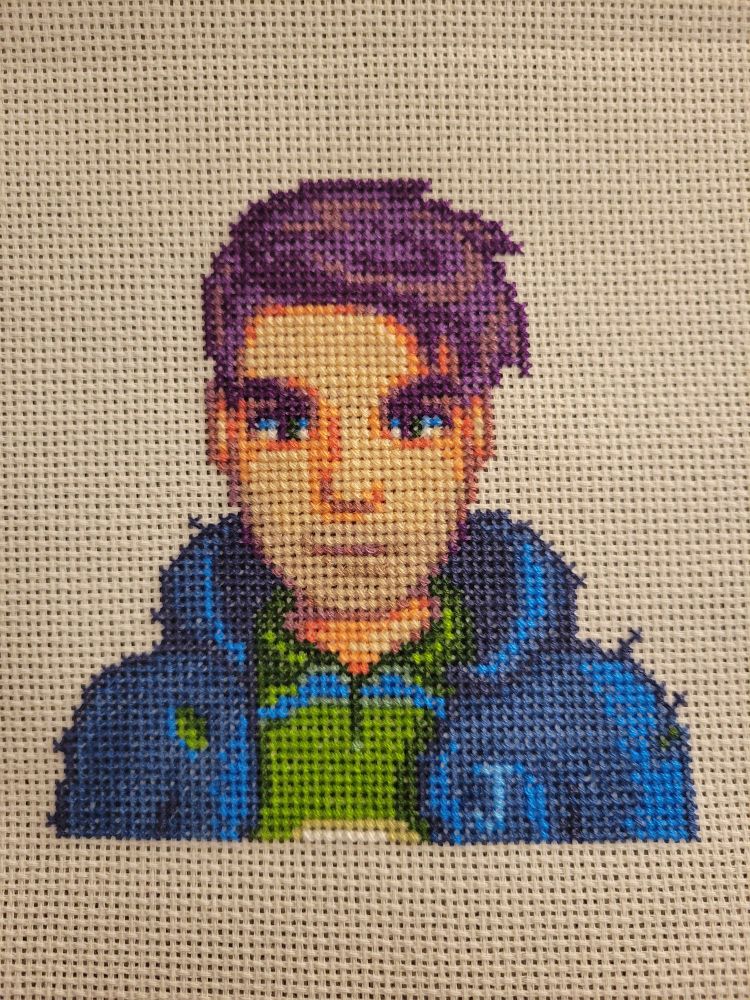 A finished cross stich of Shane from Stardew Valley