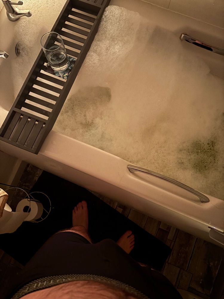 Standing over a bubble bath getting it ready for an evening relaxation