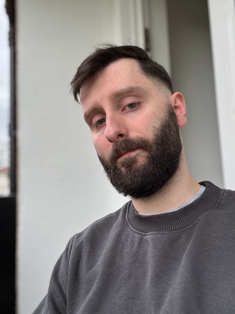 Portrait mode selfie with fresh haircut. I am sitting down outside