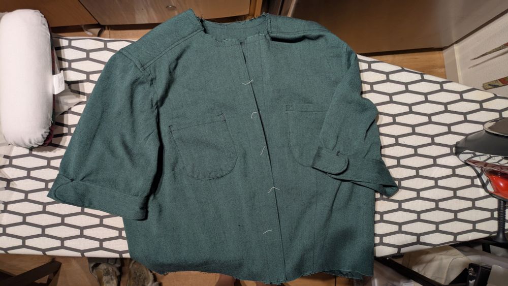 A partially finished dress lying on an ironing board. Right now, it's the bodice and sleeves, with no skirt or collar or the eventual buttons either.