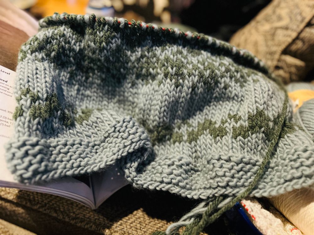 A green knit cape let with stranded colorwork