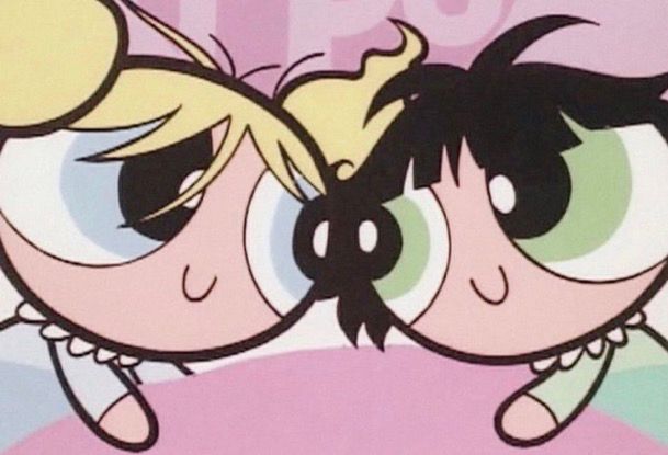 Bubbles and buttercup from the power puff girls looking at each other in bed smiling with their hair tore up