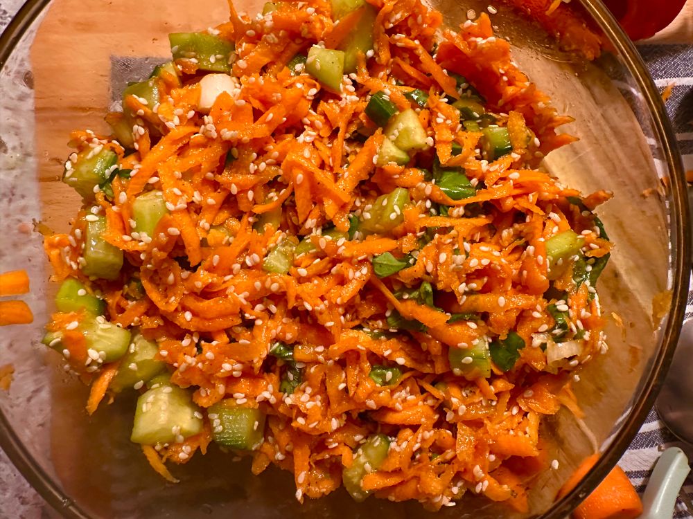 Grated carrot salad mixed with cucumbers, sesame seed, and green onions in a glass container Tossed with soya sauce, maple syrup and lime juice I immediately feel something like mouth joy when I eat this salad. I’m surprised I haven’t deepened in colour considering the amount of beta carotene It’s an actual thing and it’s called carotenemia 