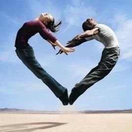 Two people jumping to form a heart shape.