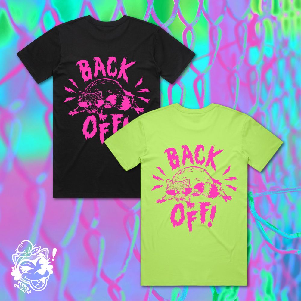 A digital flatlay of the back of two t-shirts, with a snarling cartoon of a raccoon and the text BACK OFF! in neon pink ink.