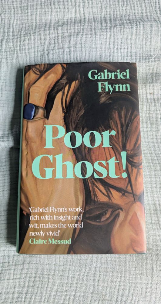 A photo of Poor Ghost! by Gabriel Flynn against a green duvet cover 