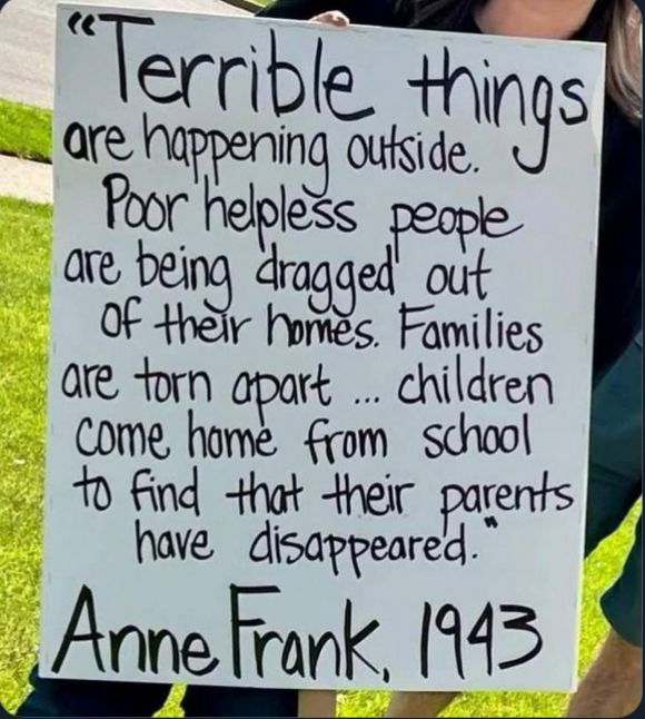 A woman holds up a sign that reads: “Terrible things are happening outside. Poor helpless people are being dragged out of their homes. Families are torn apart… Children come home from school to find their parents have disappeared.”
~Anne Frank, 1943 