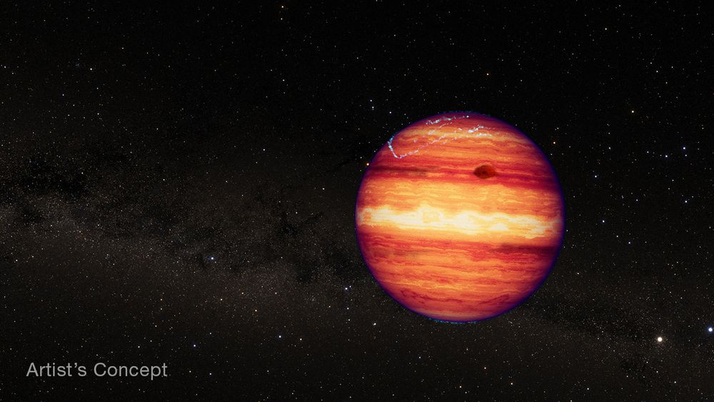 Illustration of a large spherical object that looks like a gas giant planet or a brown dwarf. The object appears to be glowing, with wavy, horizontal bands of yellow, orange, and red forming patterns similar to those in the atmosphere of Jupiter. In the mid-latitudes of the northern hemisphere, just to the right of center, is a large, elliptical, dark red feature similar to Jupiter’s Great Red Spot. Hints of a blue-green auroral glow emanate from the south pole. Larger blue-green auroral arcs descend from the north pole down toward the middle northern latitudes. The background is filled with thousands of distant stars that form a Milky Way-like band running from left to light. The object is isolated, with no host star nearby. The words “Artist’s Concept” are in the lower left corner. 
