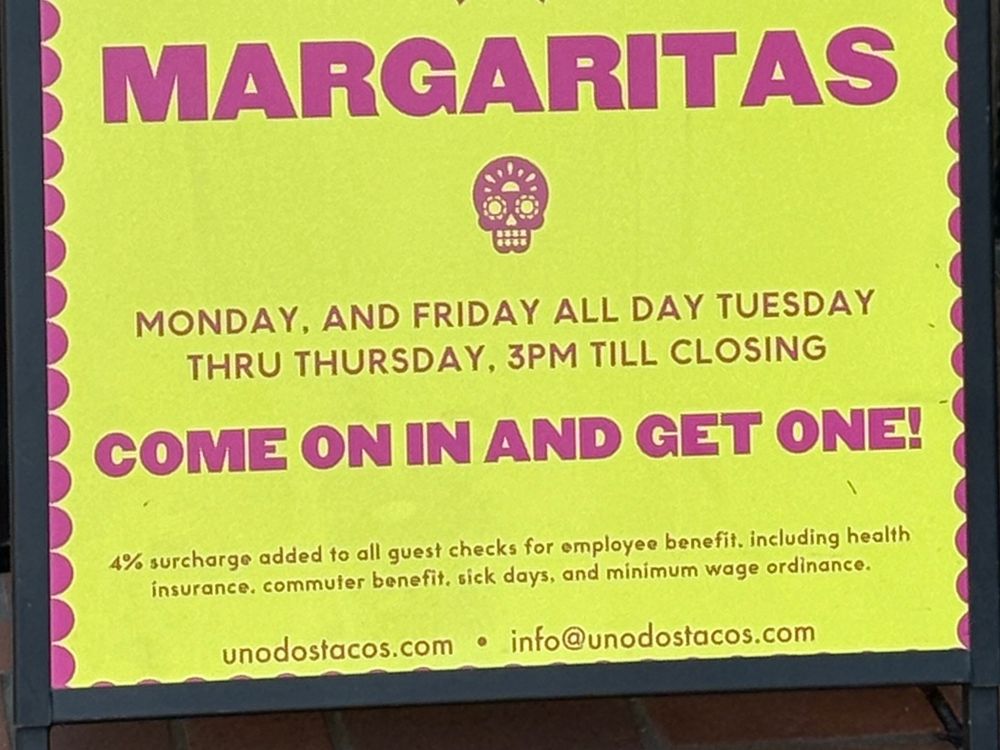 Yellow sign with pink writing that says: 
MARGARITAS
MONDAY [COMMA] AND FRIDAY ALL DAY TUESDAY
THRU THURSDAY [COMMA[ 3PM TILL CLOSING
COME ON IN AND GET ONE!