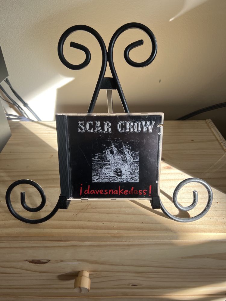 Jewel case packaging for Scar Crow's '¡Davesnakedass!' compact disc (Spanish Fly, 1993).