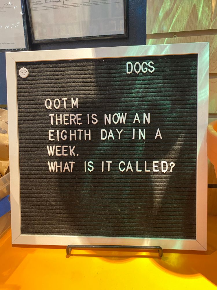 A letter board sign depicting the question of the month: “there is now an eighth day in a week. What is it called?” 
