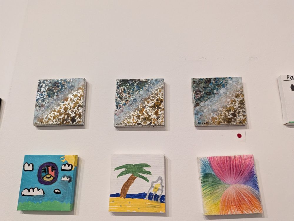 Six more canvases. A red dot is placed under one of three copies of an artistic bird's-eye view of the sea meeting the shore.