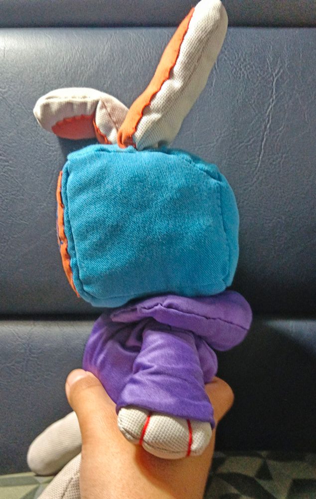 photo of my hand holding the melanie plush from the side