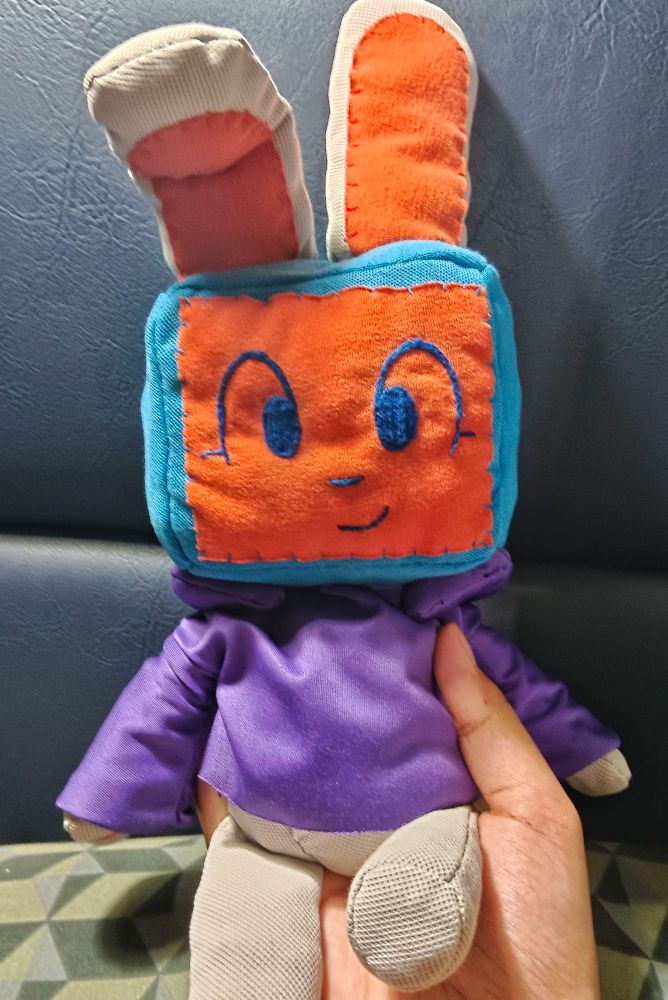 photo of my hand holding my melanie plush from the front