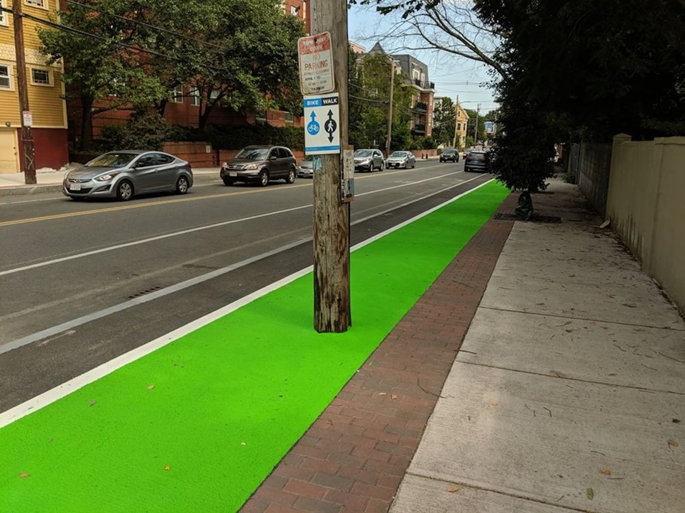 A telephone pole in the middle of a bike lane.