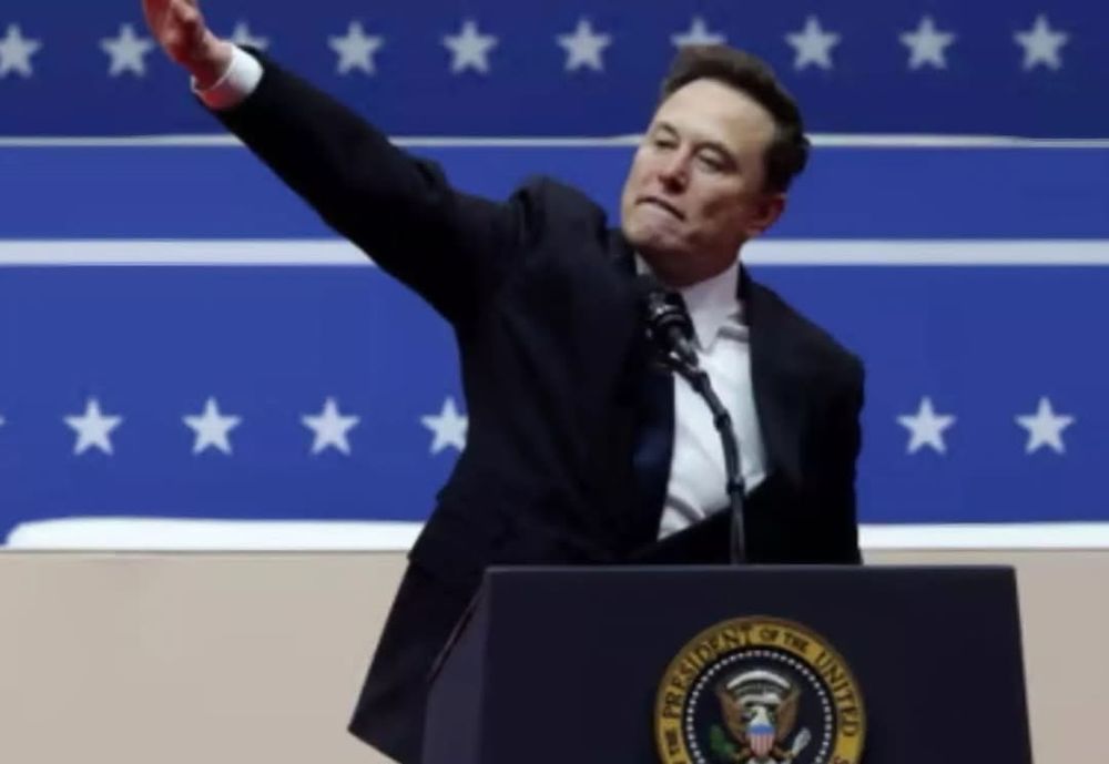 Elon Musk throwing his right arm in the air which appears to be a Roman or Hitler salute