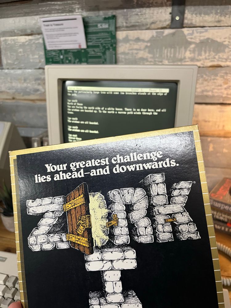Box for the text adventure game Zork in front of a late-80s PC