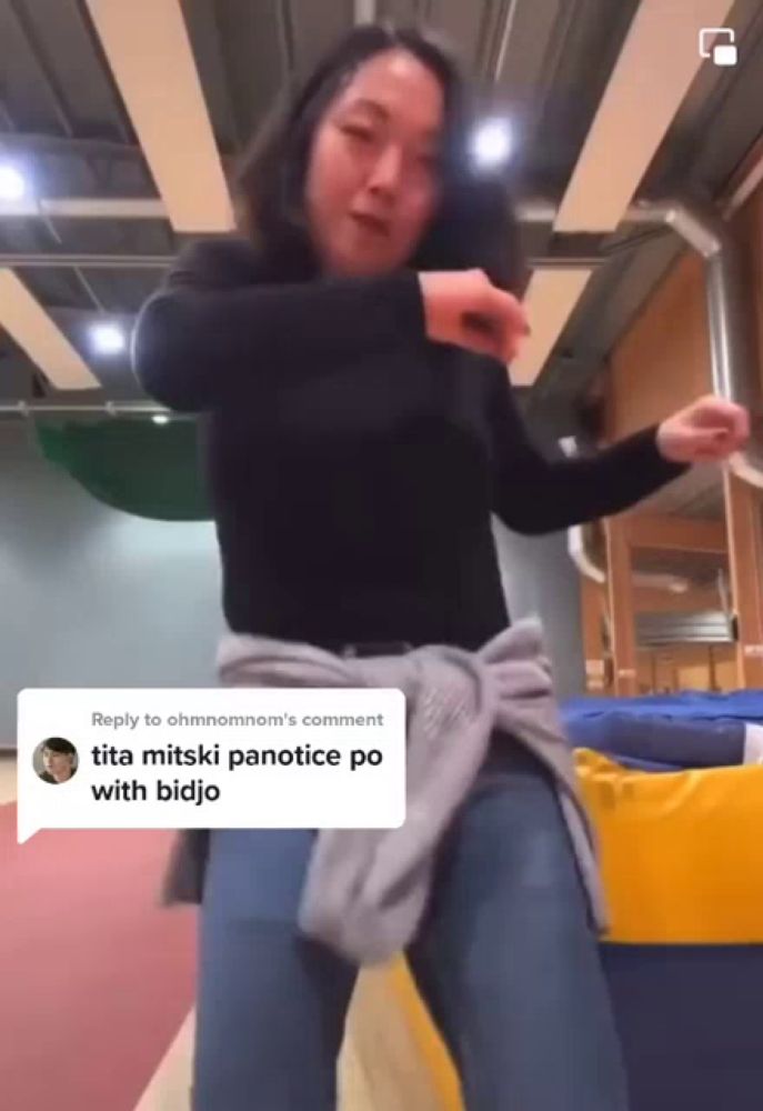 a woman in a black shirt is dancing in a gym with a comment that says tita mitski panotice po with bidjo