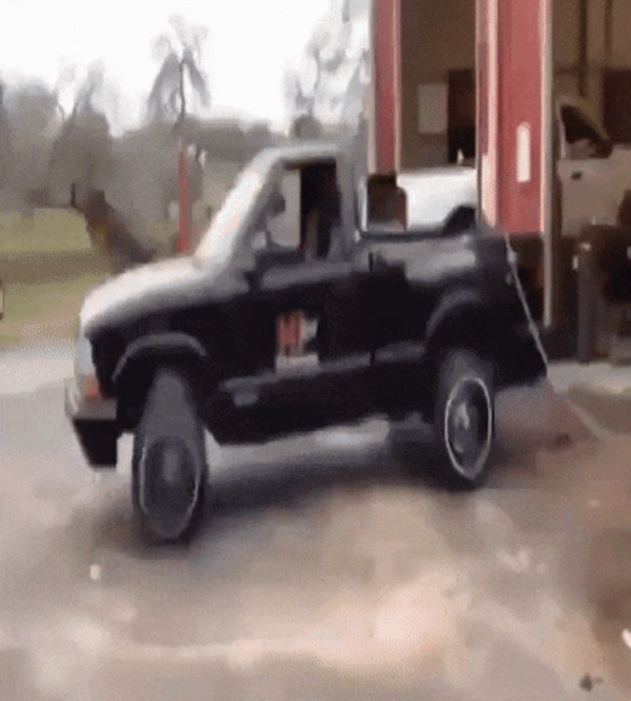 a black truck is parked in front of a gas station