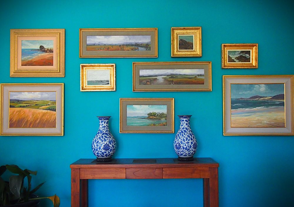 Two matching Japanese blue Lotus Flower Vases on the sideboard.
"With nine gold-framed landscape Oil Paintings contrast beautifully with the aqua-blue wall, by Noel Lieschke" 
Brisbane Queensland Australia.   