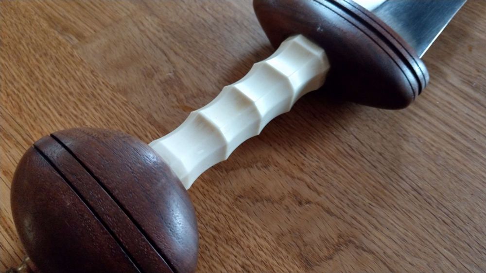 Close-up photo of the octagonal bone grip of a discontinued "Mainz-pattern" (leaf-bladed) Roman gladius short-sword.