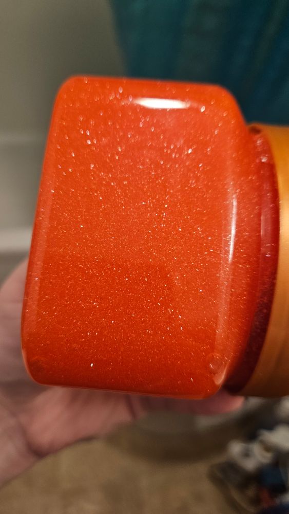 Side view of the red sugar scrub that shows the sparkles in better lighting. Very fine holographic sparkle through out.